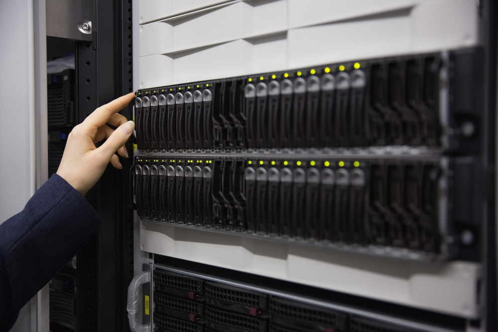 Technician working on server tower in large data center Technician working on server tower in large data center